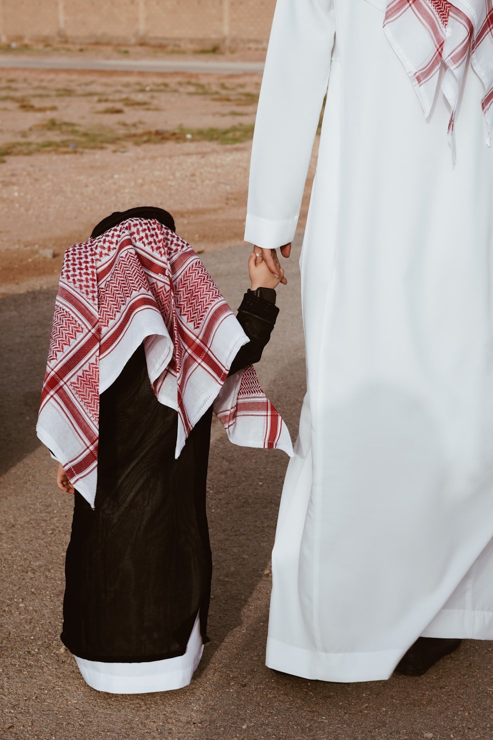 père et fils habiller en qatarie dans le désert durant voyage au Qatar